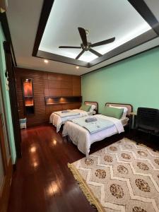 普特拉贾亚Mawar Singgah的一间卧室配有两张床和吊扇