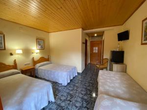 Vilanova de EscornalbouHotel Rural Cal Amadeu的酒店客房设有两张床和电视。