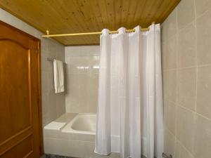 Vilanova de EscornalbouHotel Rural Cal Amadeu的浴室配有白色的淋浴帘和浴缸。