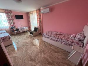 内塞伯尔Daniel Guest House的卧室设有粉红色的墙壁、一张床和一张桌子
