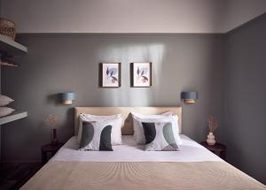 拉加纳斯Anemelia Retreat的卧室配有一张墙上三幅照片的床