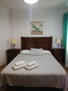 洛斯·亚诺斯·德·阿里丹Miguelangelo的一间卧室配有一张大床和两条毛巾