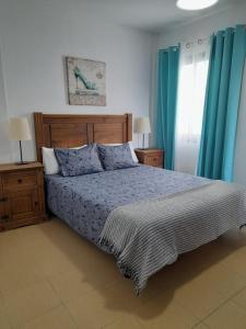 洛斯·亚诺斯·德·阿里丹Miguelangelo的一间卧室配有床和蓝色窗帘