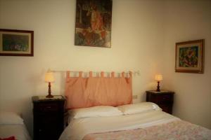 圣塞波尔克罗Agriturismo Il Giardino的一间卧室配有两张单人床和两盏灯。