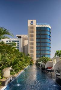 班加罗尔班加罗尔丽思卡尔顿酒店的一个带游泳池和大楼的度假胜地