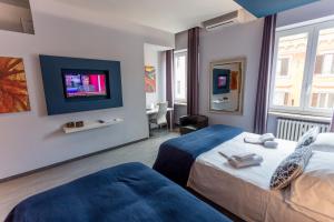罗马77号家庭食宿酒店的酒店客房设有两张床和一台平面电视。