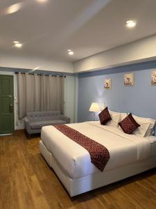 芭堤雅市中心The One Sabai Living Pattaya的卧室配有一张白色的大床和一张沙发。