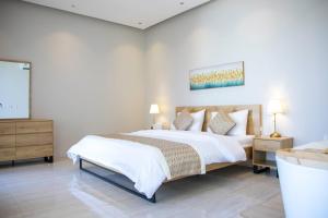 吉达شاليهات المرفأ Almarfa Resort的卧室配有一张带白色床单和枕头的大床。