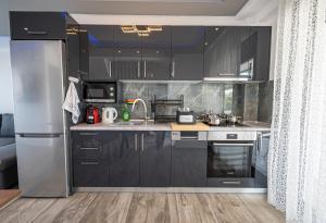 尼坡帝Chryssis Village by Travel Pro Services - Nea Potidaia Halkidiki的厨房配有黑色橱柜和不锈钢冰箱