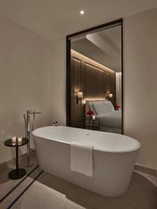 阿布扎比The Abu Dhabi EDITION的浴室设有白色浴缸及镜子