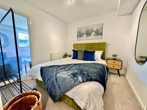 NailseaServiced Apartments Nailsea的一间卧室配有一张带蓝色枕头的大床