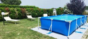 米萨诺阿德里亚蒂科Villa Circuito Simoncelli的庭院内的游泳池配有两把椅子和一张桌子