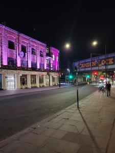 伦敦The Camden Retreat的街道边有紫色灯的建筑