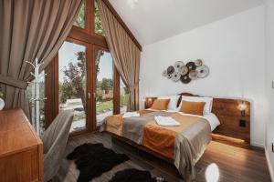 UzdojniceToplik Village Resort的一间卧室设有一张床和一个大窗户