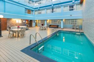 埃德蒙顿埃德蒙顿城中心康福特茵酒店的一座配有桌椅的酒店游泳池
