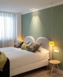 毕尔巴鄂Santiago Apartments Bilbao的卧室配有一张带两个枕头的大白色床