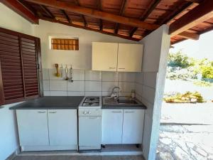 塞尔卡科德博格莫亚Robinson Ina 2的白色的厨房配有炉灶和水槽