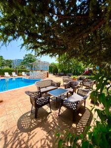 圣弗拉斯西内瓦太阳海岸公寓式酒店的游泳池旁带桌椅的天井