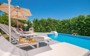 MouzákionVilla Andreas A Private Paradise的别墅配有游泳池以及带椅子和遮阳伞的天井。