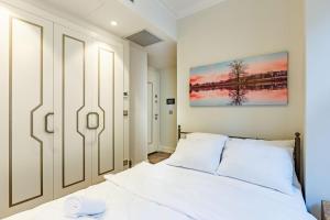 伊斯坦布尔Modern House with Central Location in Beyoglu的卧室配有白色的床和墙上的绘画作品