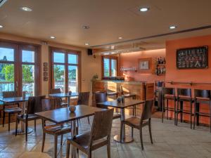 费斯卡尔德宏费斯卡多湾酒店的餐厅设有木桌、椅子和窗户。