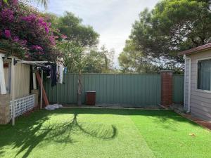 珀斯Nice house in canning vale的后院设有围栏和绿草庭院