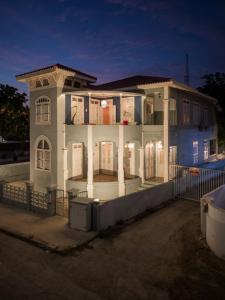 威廉斯塔德Villa Amalie & Villa Curiel的一座带柱子和栅栏的大型白色房屋