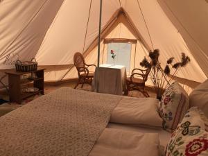 斯泰厄Helles Have Glamping的帐篷配有一张床和一张桌子及椅子