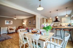 埃文河畔斯特拉特福Manor Road的厨房以及带木桌和椅子的客厅。