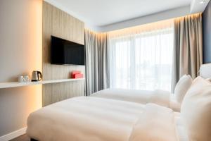 安特卫普Holiday Inn Express Antwerp - City Centre, an IHG Hotel的酒店客房设有两张床和窗户。