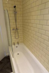 曼彻斯特The King Stay的浴室设有带淋浴的白色浴缸。