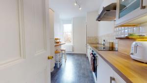 牛津The Bardwell的厨房配有白色橱柜和木制台面