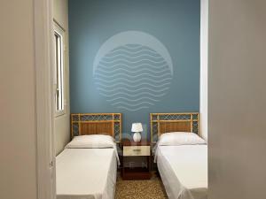 托雷拉皮罗Villa Capitano的蓝色墙壁客房的两张床