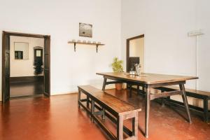 迈索尔Laika Heritage Stay的一间用餐室,在房间内配有桌子和长凳
