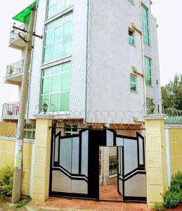 亚的斯亚贝巴Keba Guesthouse的一座白色的大建筑,设有黑色的大门
