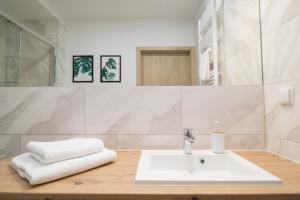 波兰尼卡-兹德鲁伊Apartamenty Dębowa 3的白色的浴室设有水槽和镜子
