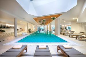 杜布罗夫尼克Valamar Lacroma Dubrovnik Hotel的一座配有桌椅的酒店游泳池