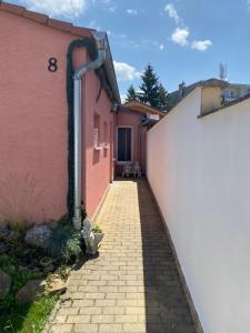 皮耶什佳尼Rodinný dom Auris的一条通往粉红色建筑的砖巷