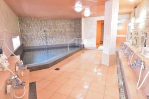 琴平町こんぴら温泉湯元八千代的大楼内带游泳池的大型浴室