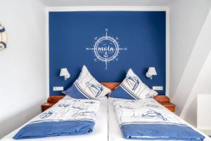 威克奥夫弗尔阿尔福斯藤岛上酒店的一间卧室设有蓝色的墙壁和两张床