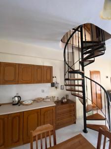 卡尼奥提Loft Oasis的厨房里设有螺旋楼梯,配有桌椅