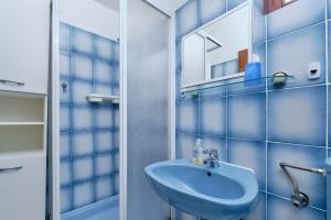 木洛希尼Apartments Marija的蓝色的浴室设有水槽和镜子