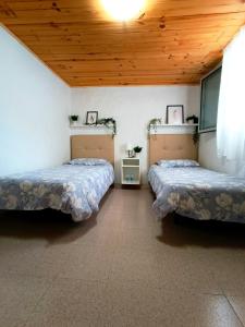 El RiscoB&B and Apartments El Charco Azul的配有木天花板的客房内的两张床
