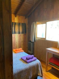 圣马丁德洛斯Cabaña de Montaña的一间卧室配有一张床,上面有两条毛巾