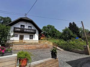 费尔德基兴Lendorfer Cottage的白色的房子,有黑色的屋顶和一些植物