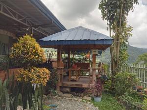 巴纳韦Banaue Pink Eco hostel的花园内带蓝色屋顶的凉亭