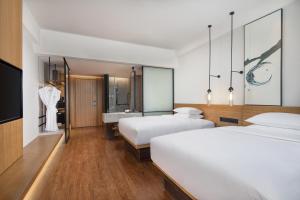白银白银万枫酒店的酒店客房设有两张床和盥洗盆