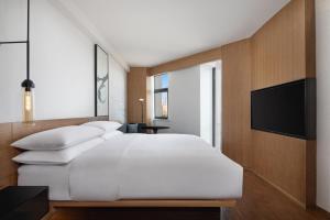 白银白银万枫酒店的卧室配有一张白色大床和一台平面电视。