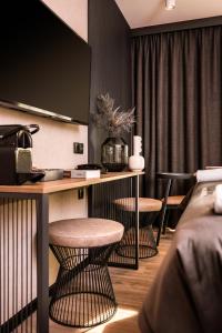 格但斯克Royal Apartments - Boutique Residence Gdańsk的酒店客房设有一张桌子和两张凳子