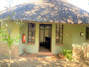 布拉瓦约Double lodge on natural African bush - 2112的茅草屋顶和红色消防栓的小房子